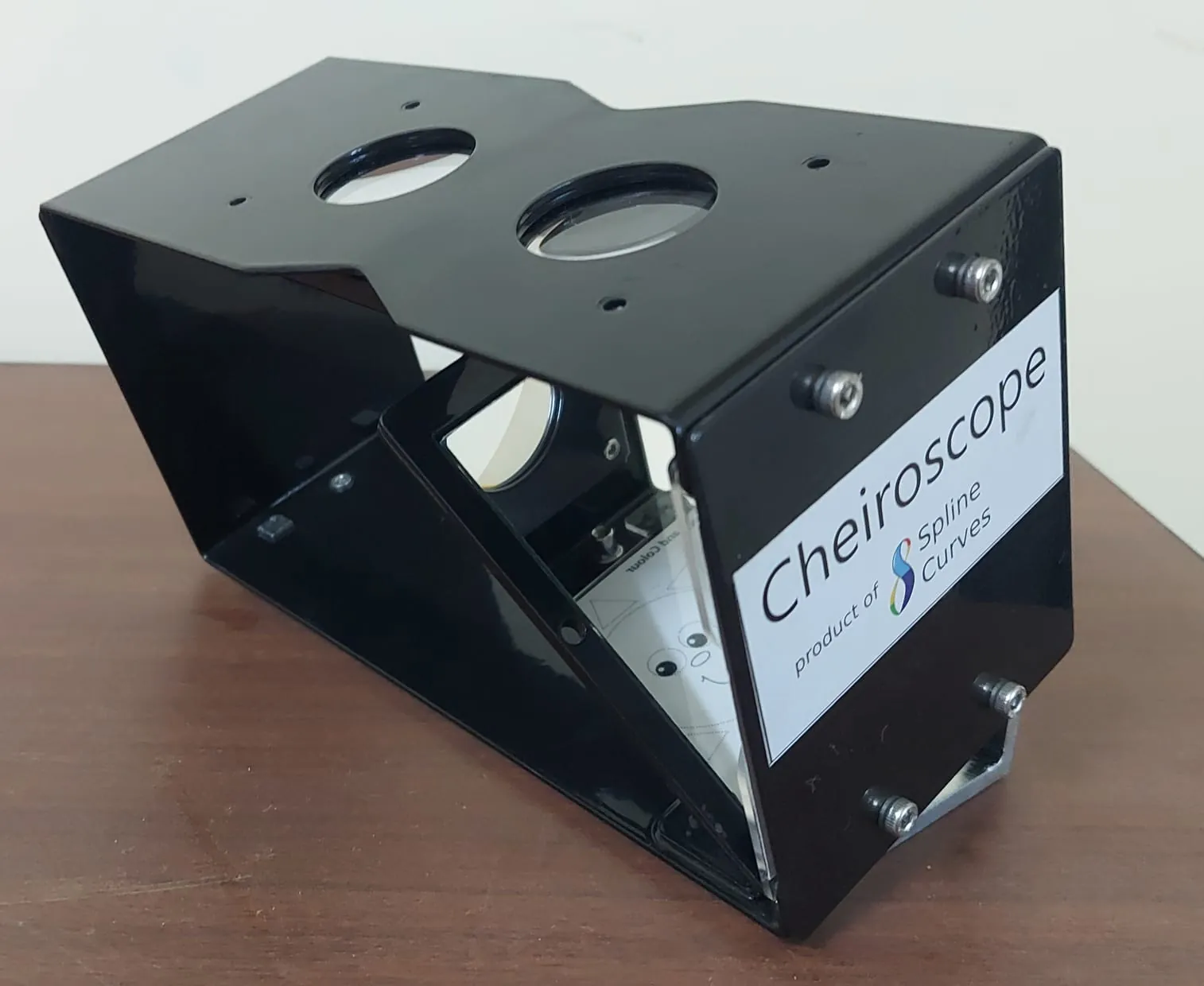 The Cheiroscope, a gloss black sheet metal vision therapy instrument made by Spline Curves